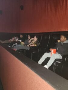 Children watching a movie in a dark theater.